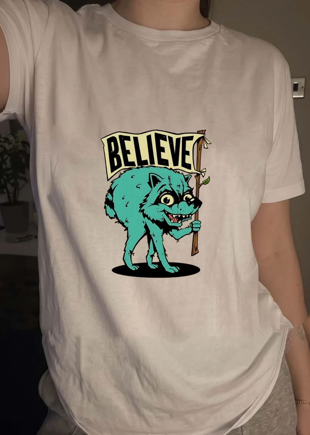 Believe Raccoon Carrying A Sign shirt